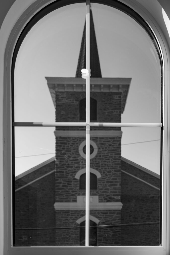Photo of the bell tower through a window at The Roe at Manayunk